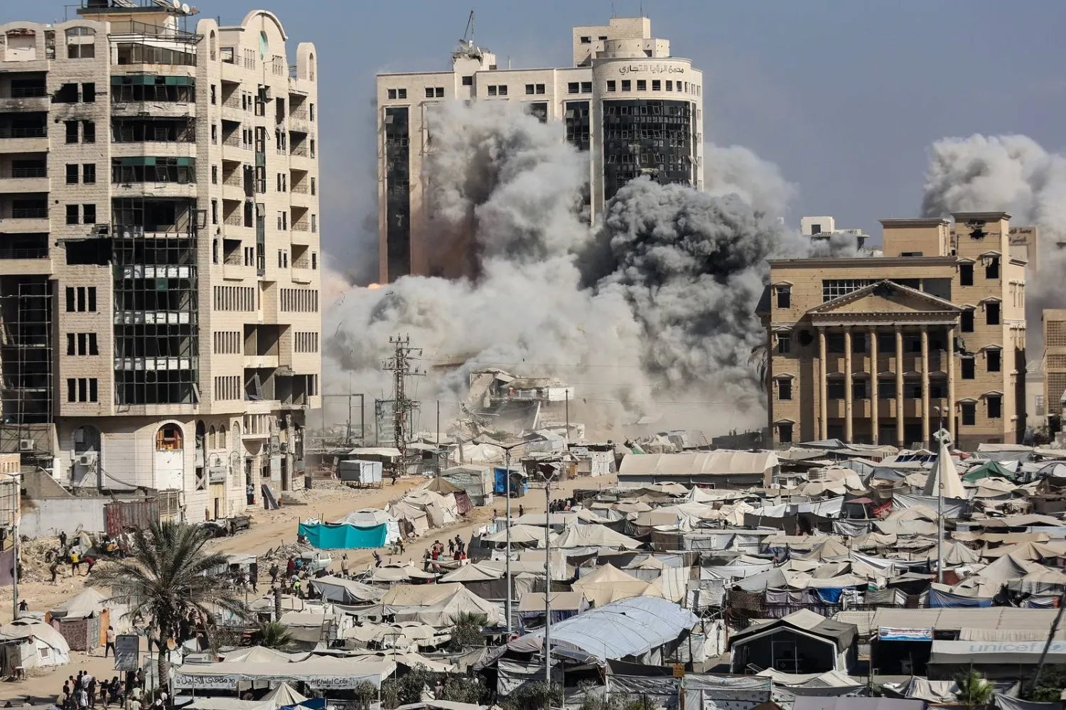 تصاعد الدخان خلال قصف إسرائيلي على مبنى بالقرب من خيام تؤوي نازحين فلسطينيين في منطقة الرمال بغزة (أ.ف.ب)