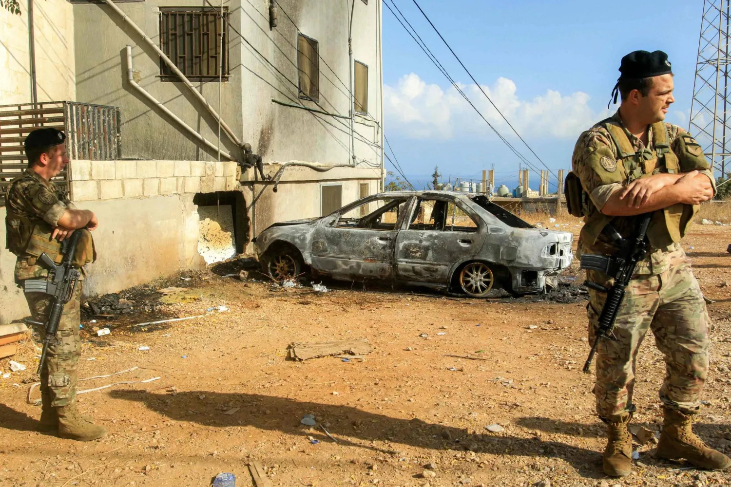 Lebanese army soldiers and security forces deploy near a vehicle that was hit by a reported drone-strike at the entrance of the village of Barja, about 30 kilometers south of Beirut, on September 9, 2025.  (Photo by Mahmoud ZAYYAT / AFP) 
