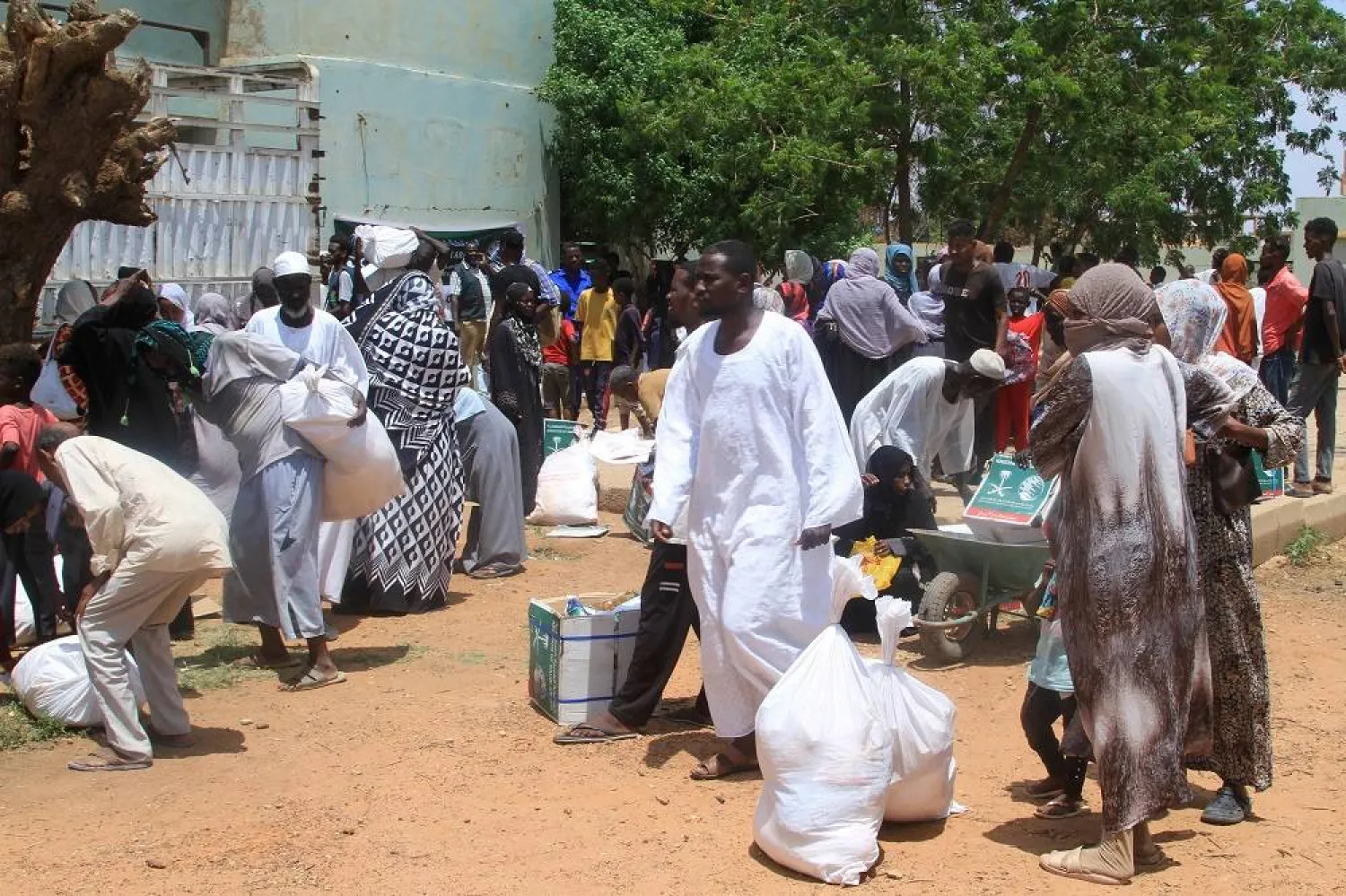 Sudanese queue to receive humanitarian aid in the Al-LaMap district of Khartoum on September 8, 2025. (AFP) 
