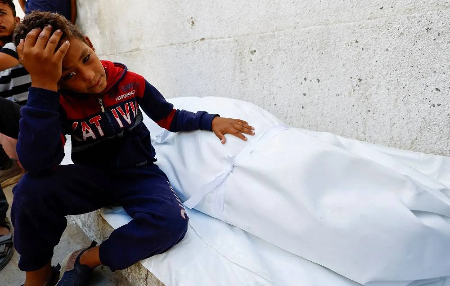 A boy reacts next to the body of a Palestinian killed in overnight Israeli strikes, according to medics, at Al-Shifa Hospital in Gaza City, September 9, 2025. (Reuters)