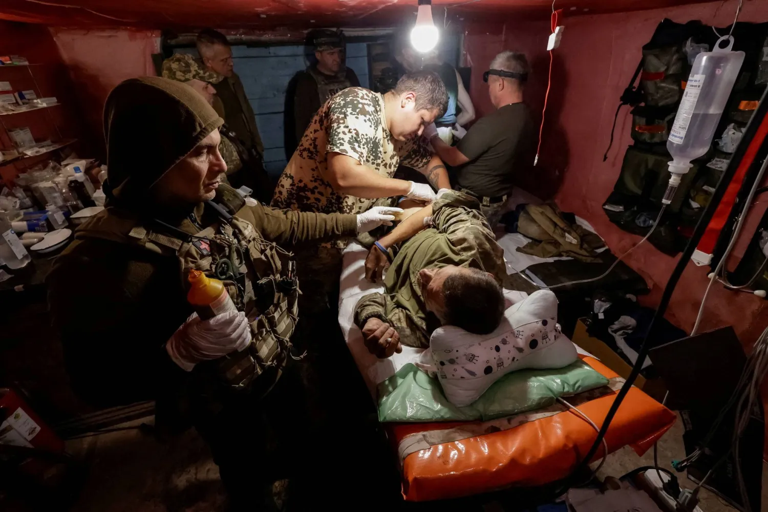 مسعفون يعالجون جندياً أوكرانياً مصاباً بالقرب من خط المواجهة في منطقة دونيتسك (رويترز)