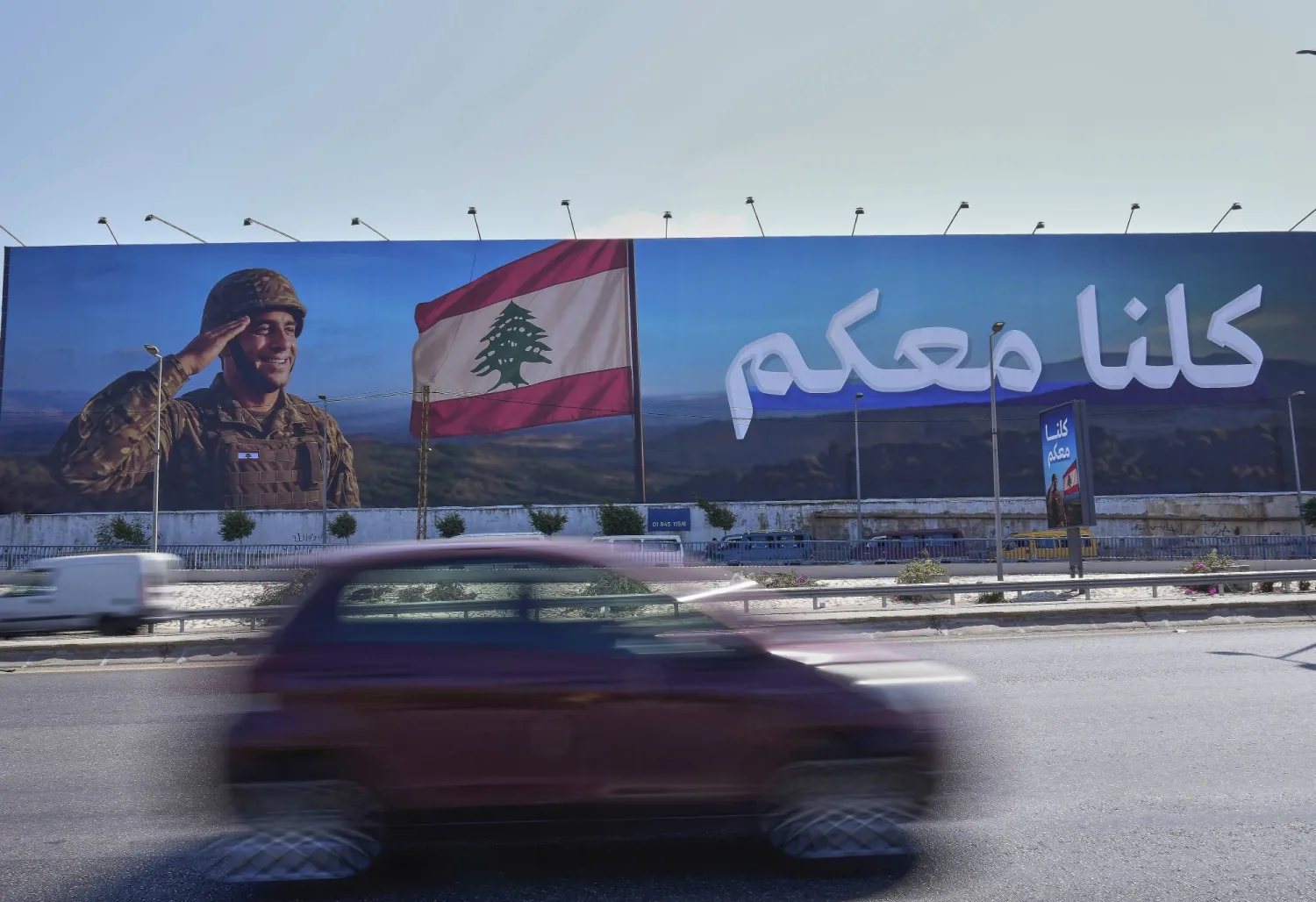 سيارة تمر أمام لوحة إعلانية لدعم الجيش اللبناني موضوعة على الطريق السريع المؤدي إلى مطار بيروت الدولي (أ.ب)