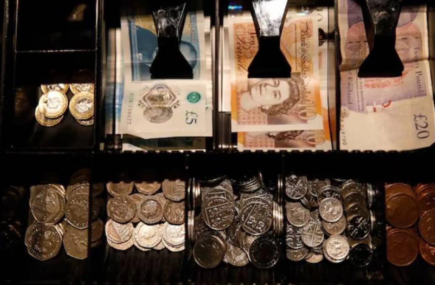 أوراق نقدية وعملات معدنية من فئة الجنيه الإسترليني في مقهى بمانشستر (رويترز)