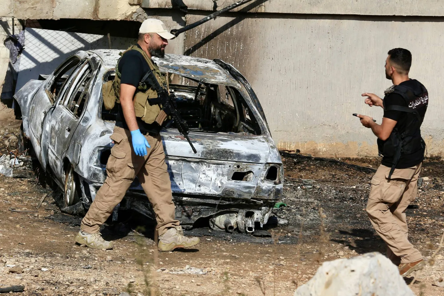 عناصر من مخابرات الجيش اللبناني يجمعون الأدلة من موقع استهداف إسرائيلي لسيارة بجبل لبنان (إ.ب.أ)