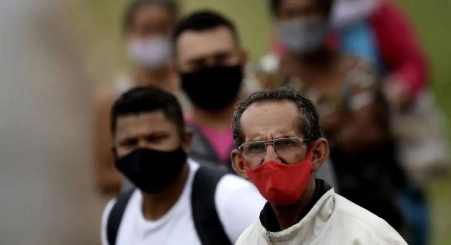 أشخاص يرتدون أقنعة الوجه الواقية خلال انتظارهم ركوب إحدى الحافلات في البرازيل (أرشيفية- أ.ب)