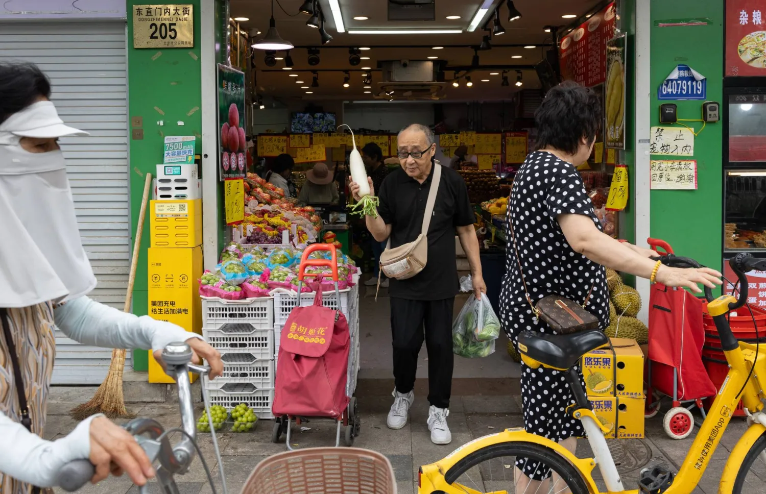 متسوقون خارج أحد المتاجر بالعاصمة الصينية بكين (إ.ب.أ)