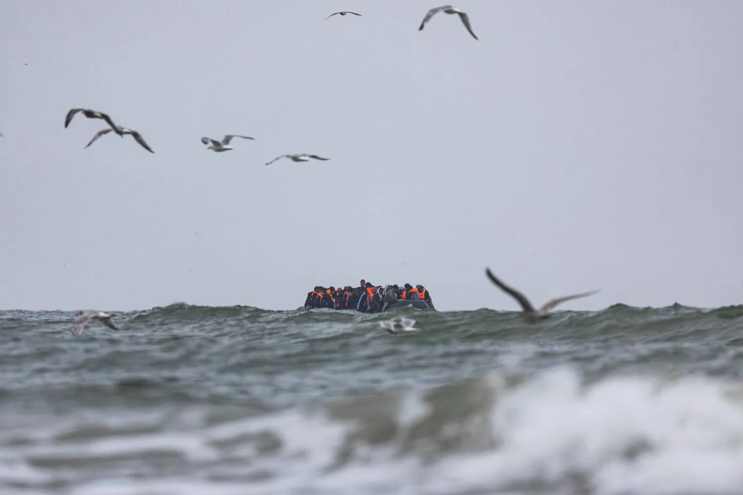 (FILES) Migrants onboard a smuggler's boat sail in the French water in an attempt to cross the English Channel off the beach of Hardelot in Neufchatel-Hardelot, northern France on August 13, 2025. (Photo by Sameer Al-DOUMY / AFP)