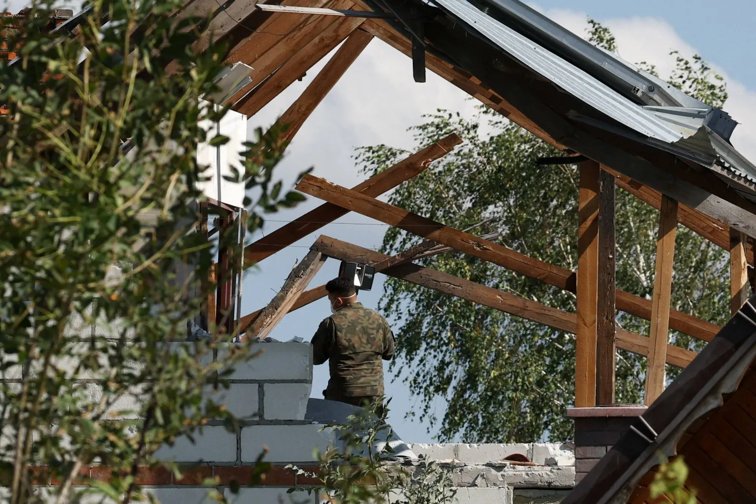 عنصر من الجيش البولندي يتفقد منزلاً متضرراً جراء سقوط طائرة مسيّرة في ويريكي بمحافظة لوبلين... بولندا 10 سبتمبر 2025 (رويترز)