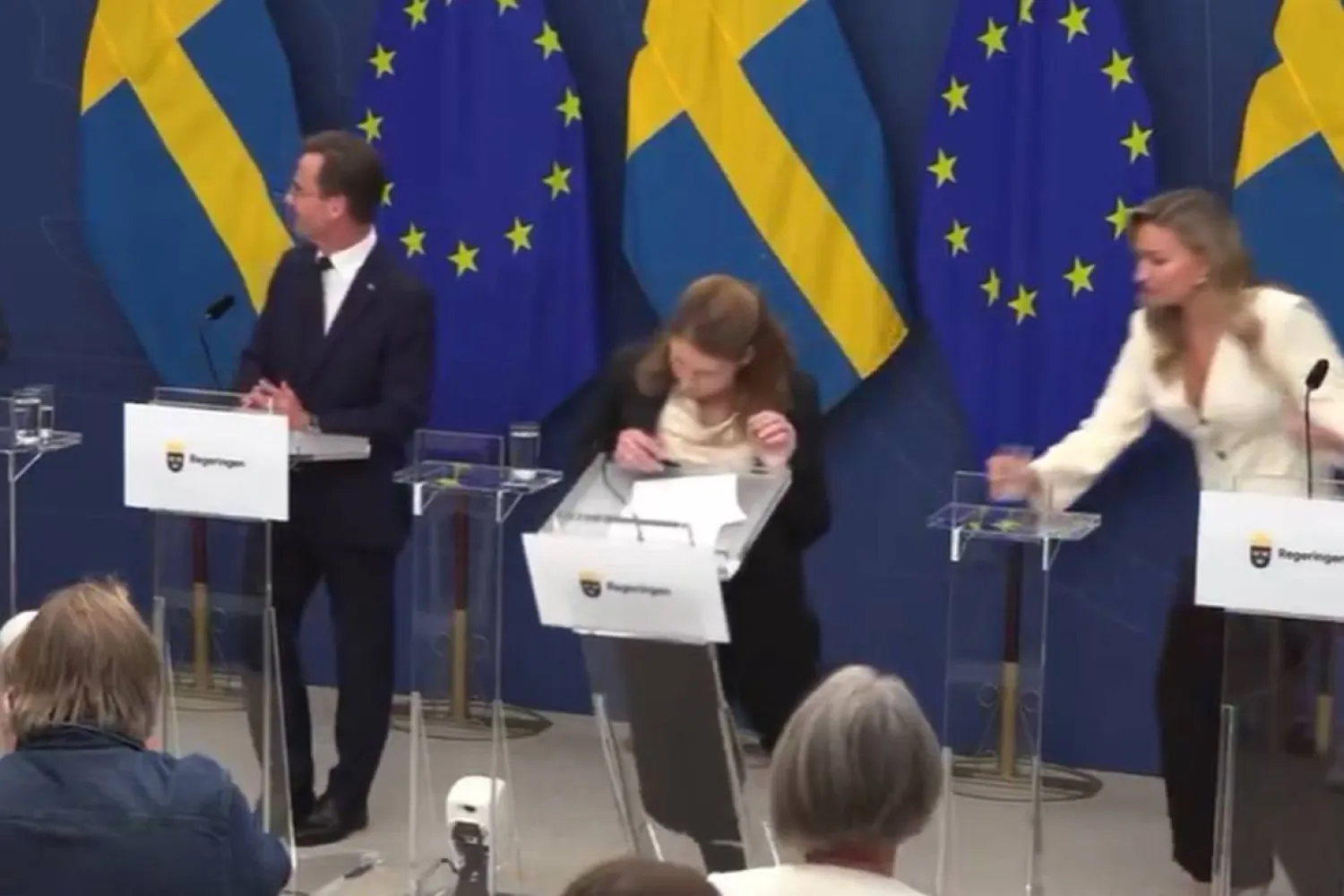 صورة مثبتة من مقطع فيديو للان وهي تفقد وعيها على المنصة أمام الصحافيين