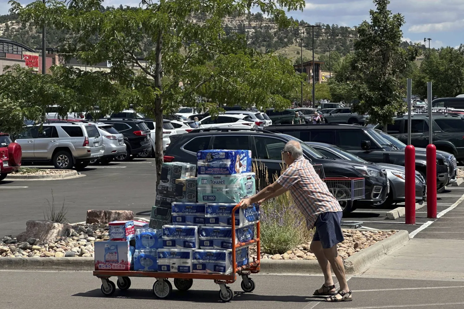 متسوق يدفع عربة محملة بالمواد الورقية داخل موقف سيارات بأحد مخازن سلسلة متاجر «كوستكو» في كولورادو (أ.ب)