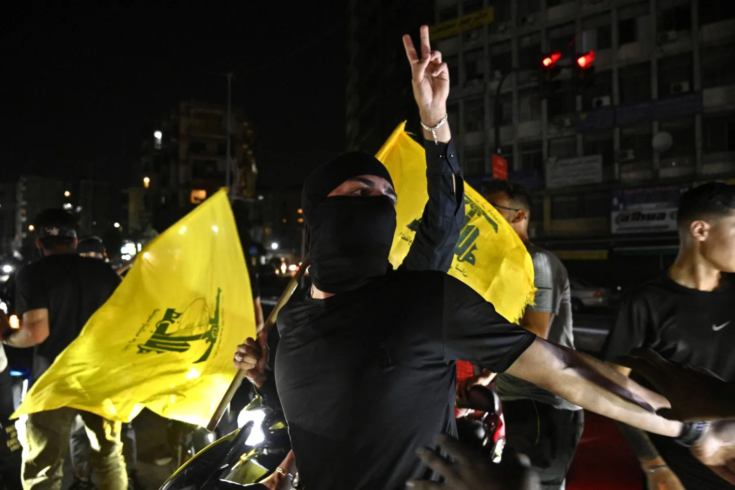 مناصرون لـ«حزب الله» يرفعون أعلامه خلال تحرك معارض لـ«حصرية السلاح» في ضاحية بيروت الجنوبية (إ.ب.أ)