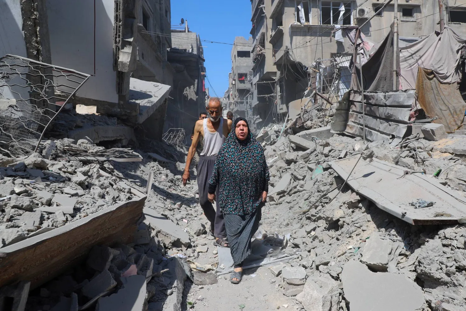 فلسطينيون يسيرون وسط الأنقاض بعد أن ضربت غارة إسرائيلية مبنى تم إخلاؤه في مخيم الشاطئ للاجئين بمدينة غزة 11 سبتمبر 2025 (رويترز)