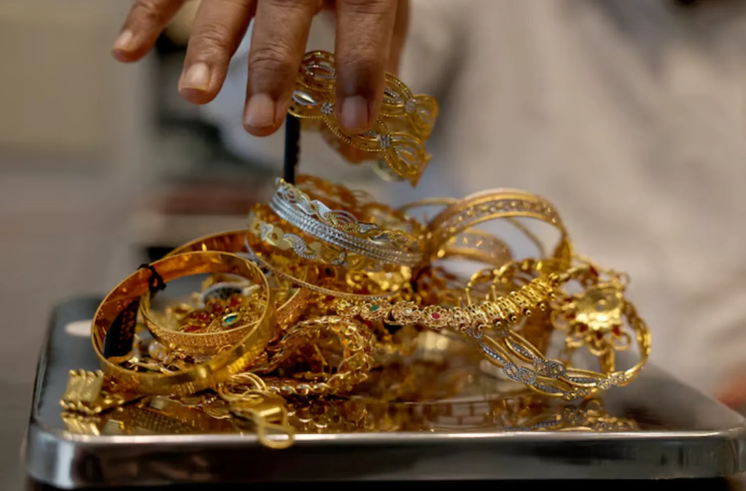 A goldsmith weighs gold jewellery inside a showroom in Ahmedabad, India, July 31, 2025. REUTERS/Amit Dave/File Photo 