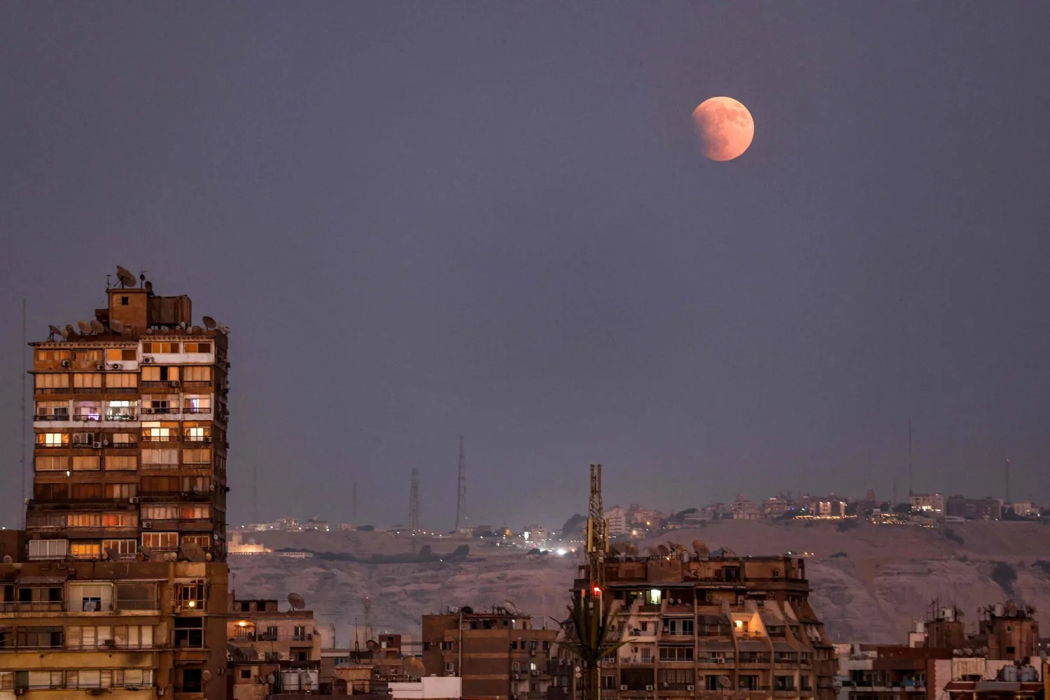 The "Blood Moon" is pictured during the beginning of a lunar eclipse above Cairo on September 7, 2025. (Photo by MOHAMMED ABED / AFP)