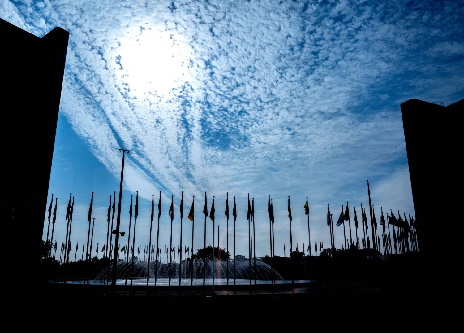 Shiloutted flags are seen in the courtyard of the UN district during the Board of Governors meeting of the International Atomic Energy Agency (IAEA) at its headquarters in Vienna, Austria on September 8, 2025. (Photo by Joe Klamar / AFP)