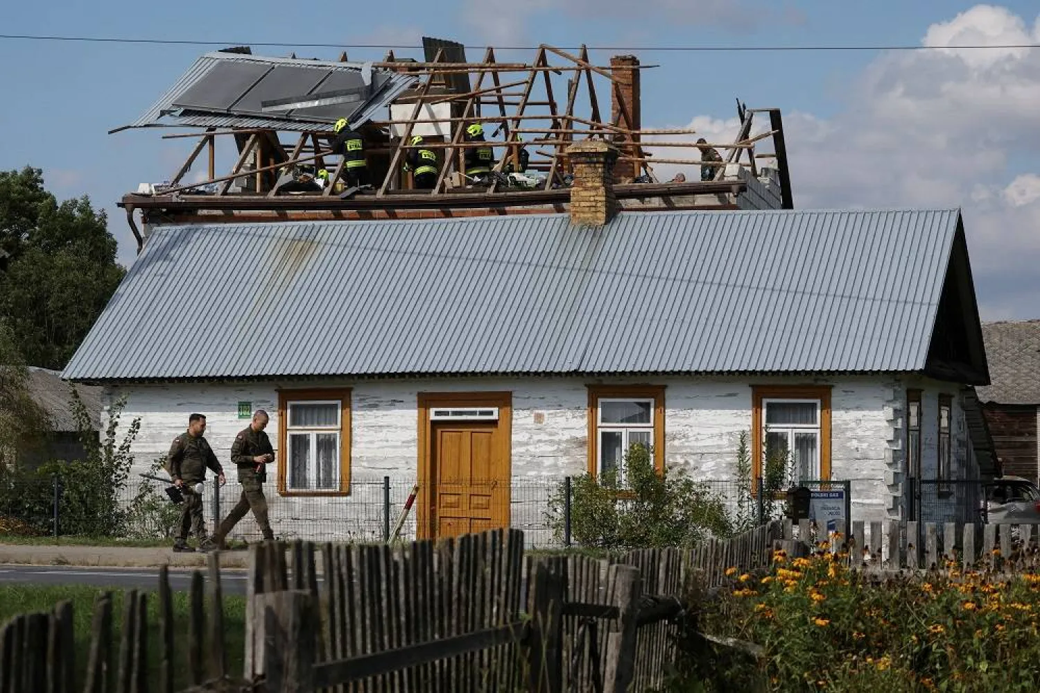 Polish soldiers walk below as firefighters work on the destroyed roof of a house, after Russian drones violated Polish airspace during an attack on Ukraine, with some being shot down by Poland with the backing from its NATO allies, in Wyryki-Wola, Lublin Voivodeship, Poland, September 10, 2025. (Reuters)