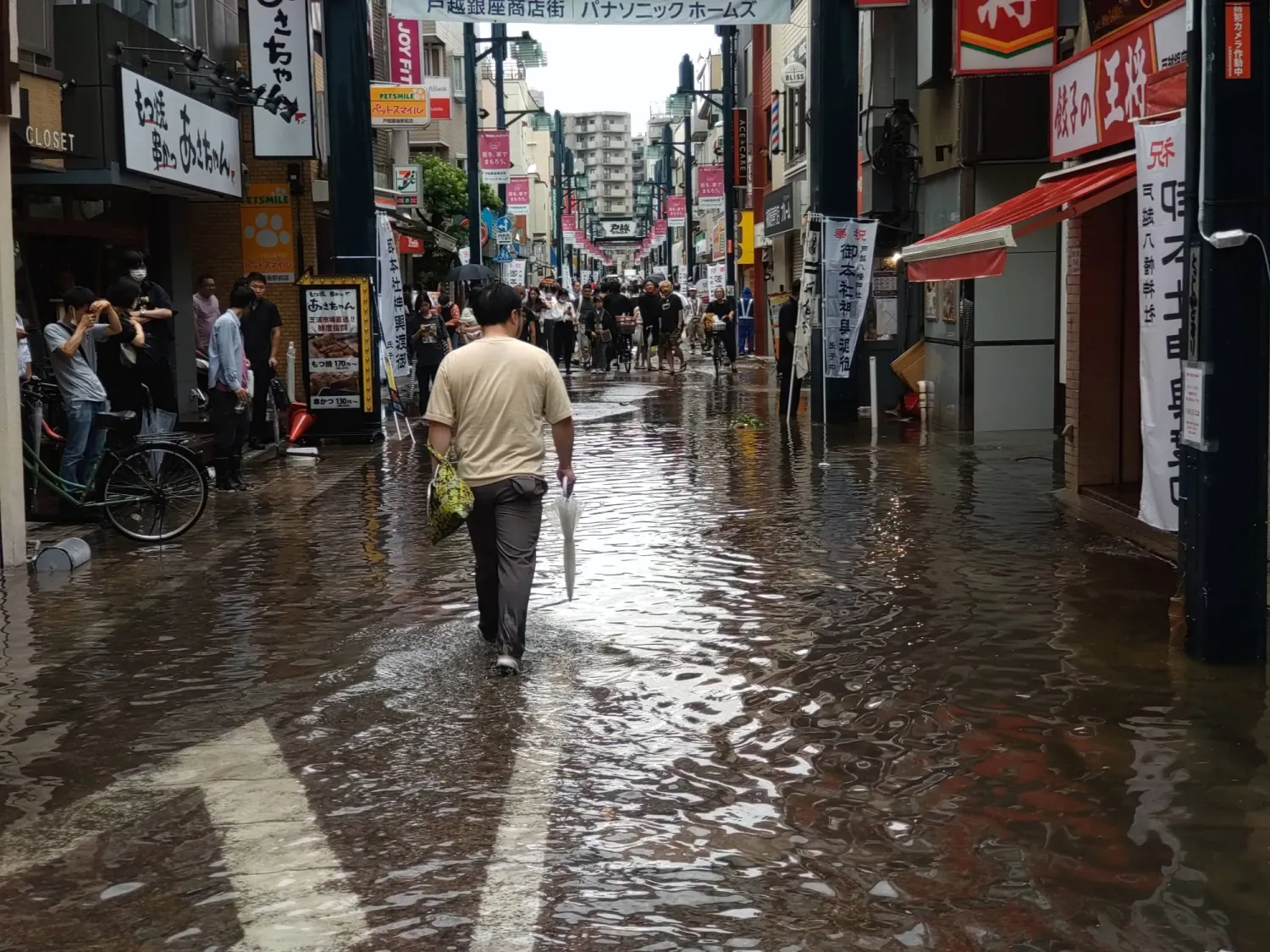 رجل يسير تحت أمطار غزيرة في العاصمة اليابانية طوكيو (إ.ب.أ)