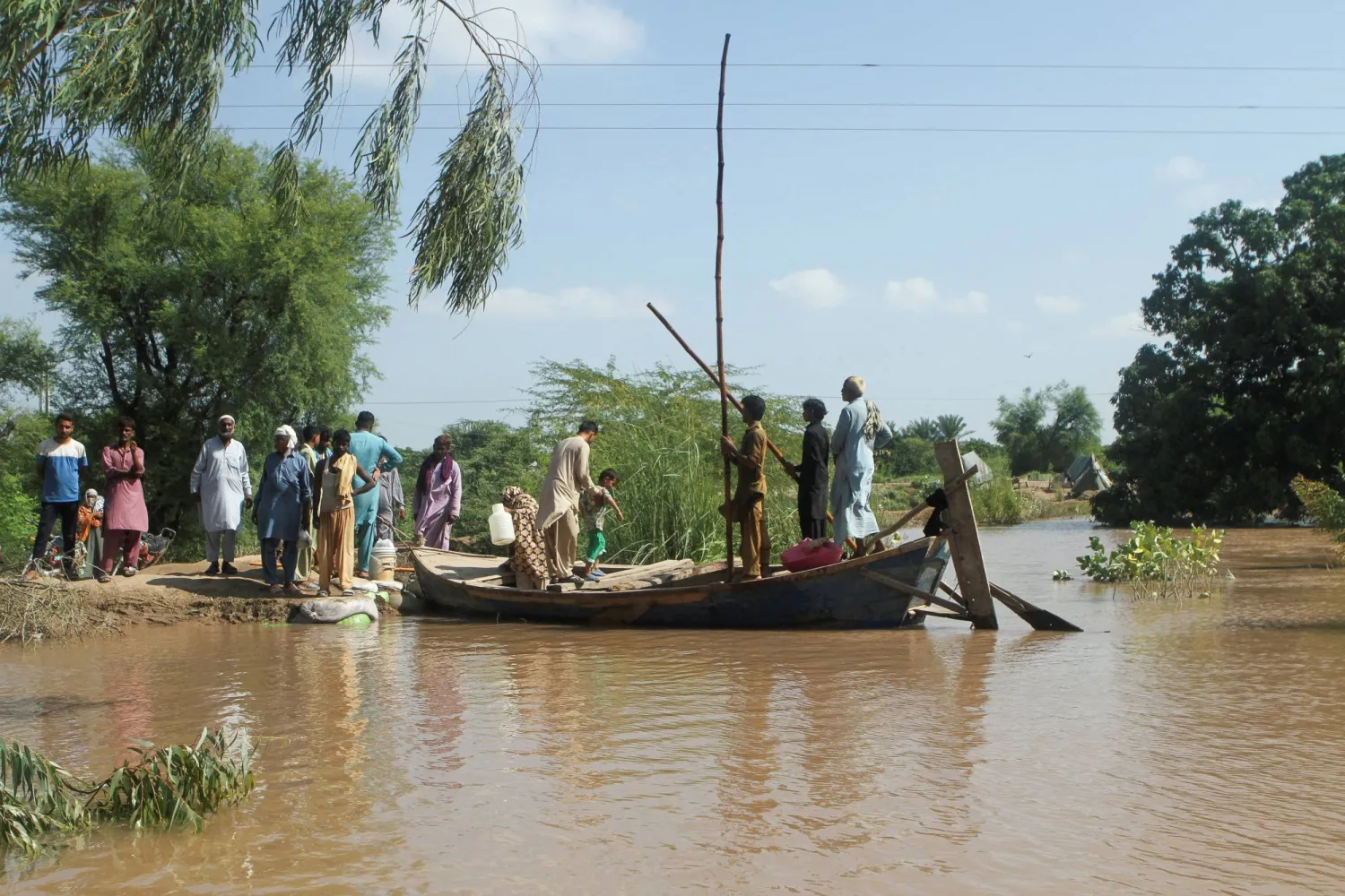 Residents board a boat while others wait for Rescue 1122 boat as they evacuate from the flooded area, following monsoon rains and rising water levels of the Chenab River, in Qasim Bela village on the outskirts of Multan in Punjab province, Pakistan, September 11, 2025. REUTERS/Quratulain Asim