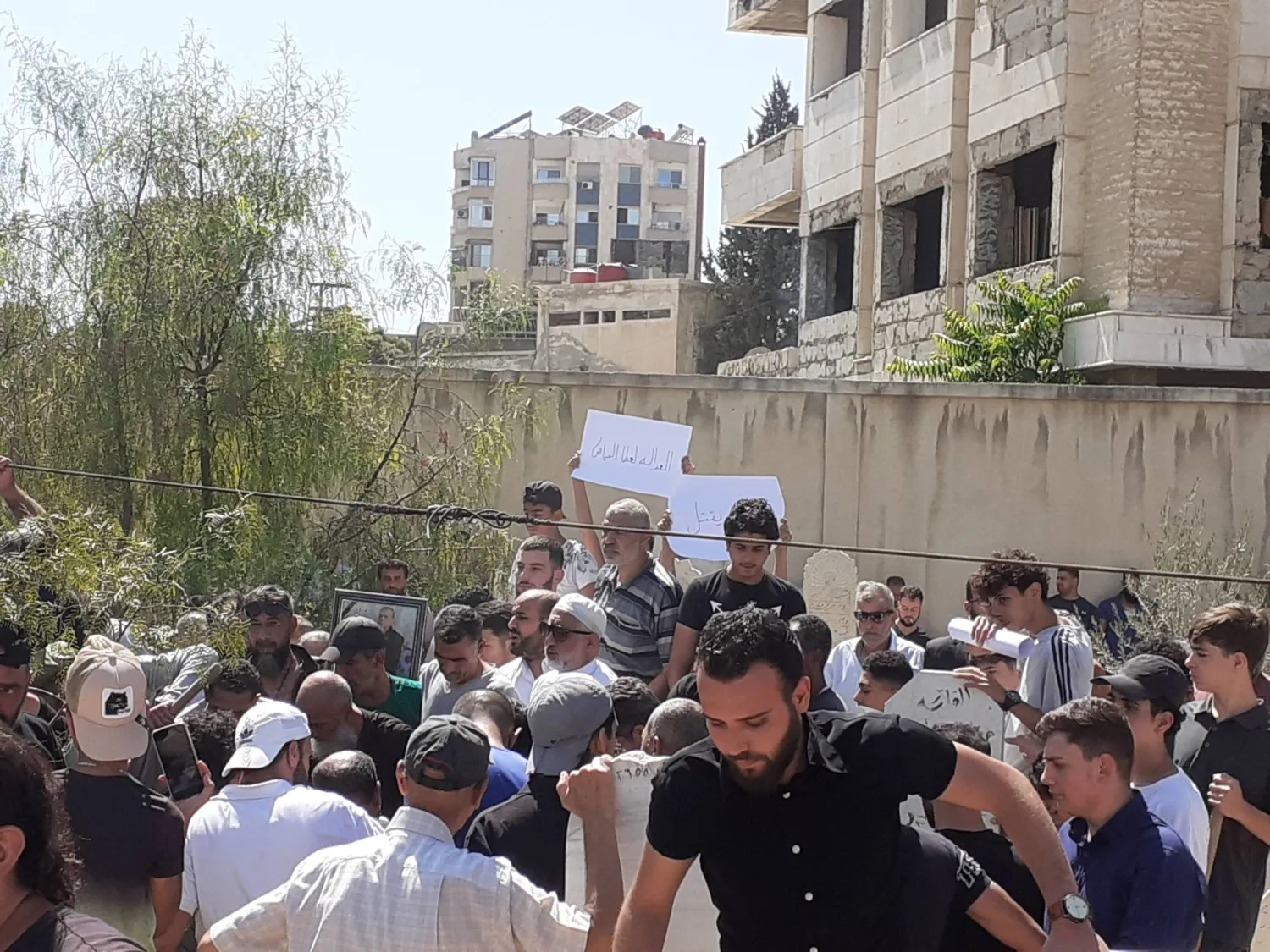 مشاركون في مراسم دفن عطا صالح الفياض في مقبرة حي القابون شمال دمشق (الشرق الأوسط)  