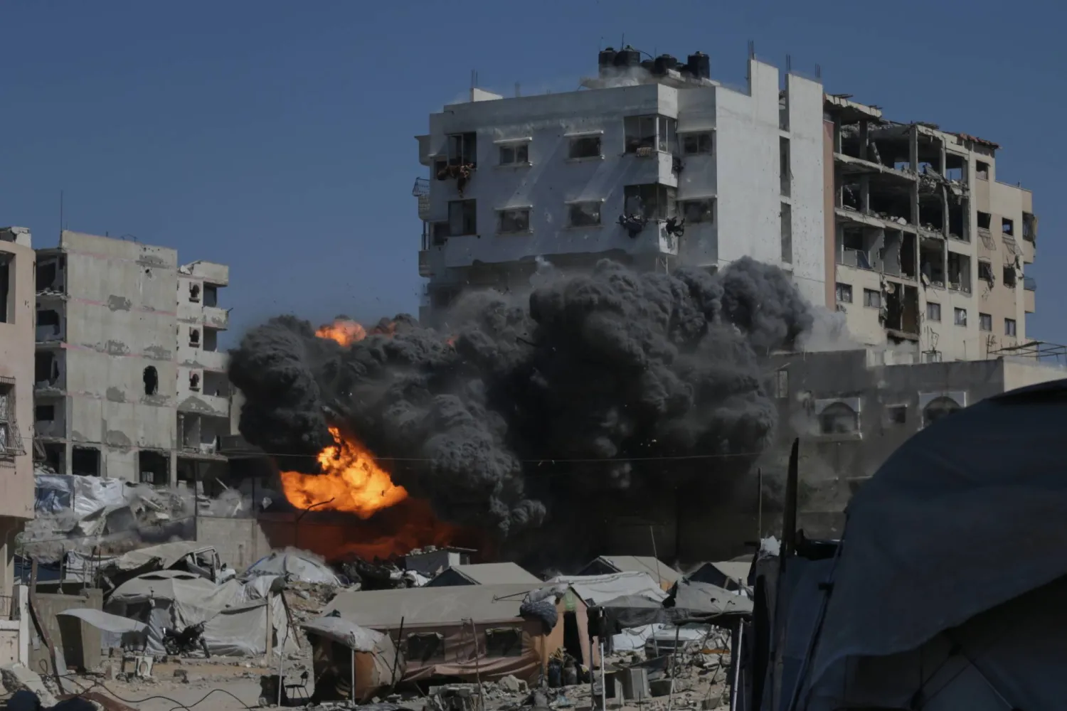 تصاعد النيران والدخان عقب غارة إسرائيلية على مبنى في مدينة غزة (أ.ب)