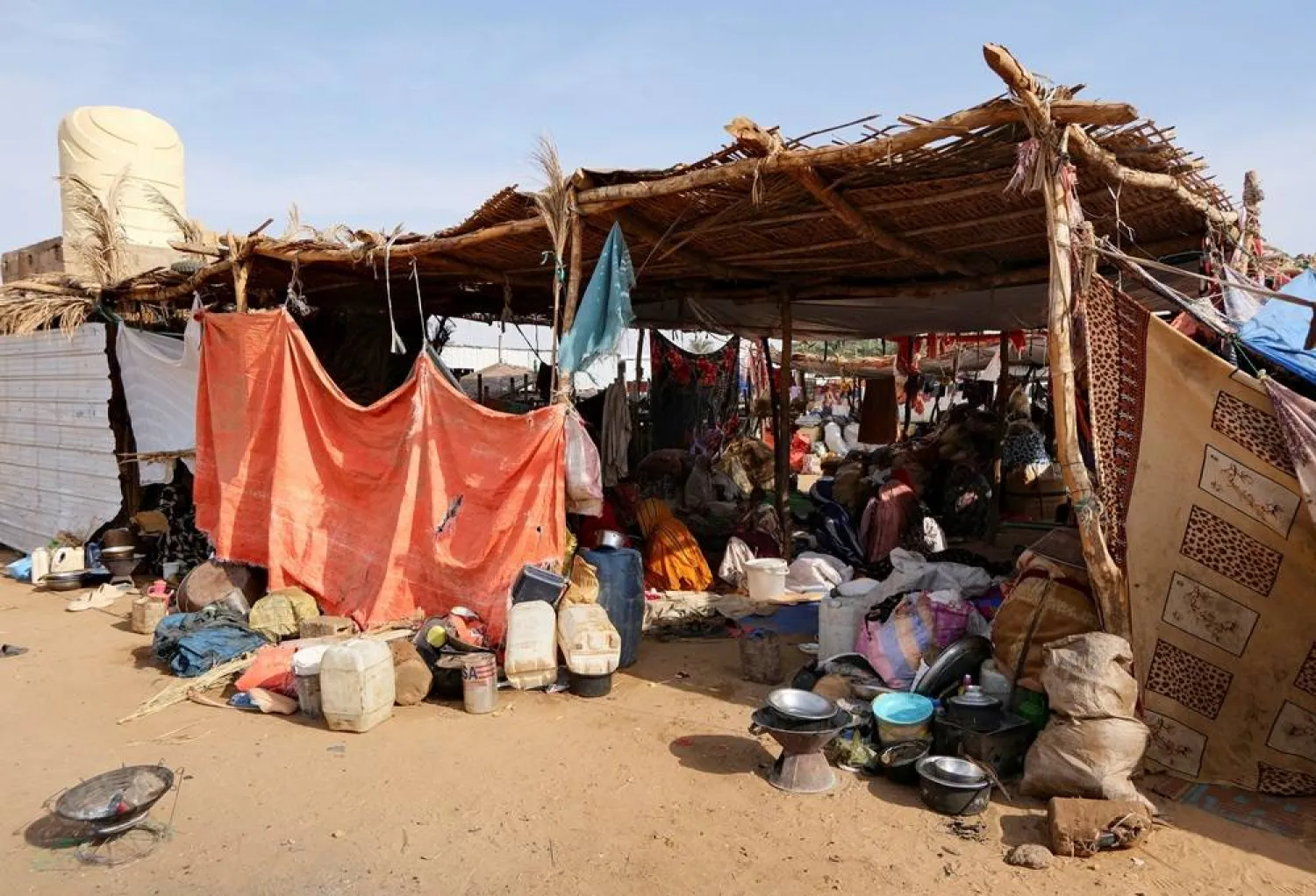Sudanese women who fled intense fighting in al-Fashir sit in a tent made of straw and tree branches at a displacement camp, as the humanitarian situation deteriorates amid the ongoing conflict between the RSF and the Sudanese army, in Al Dabba, Sudan, September 6, 2025. (Reuters)