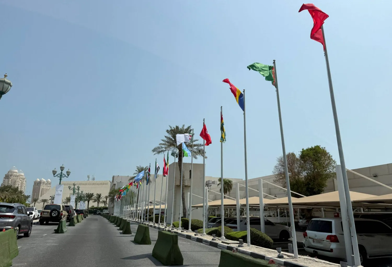 ترفرف الأعلام العربية والإسلامية بينما تستعد قطر لاستضافة القمة الطارئة في فندق شيراتون بالدوحة (رويترز)