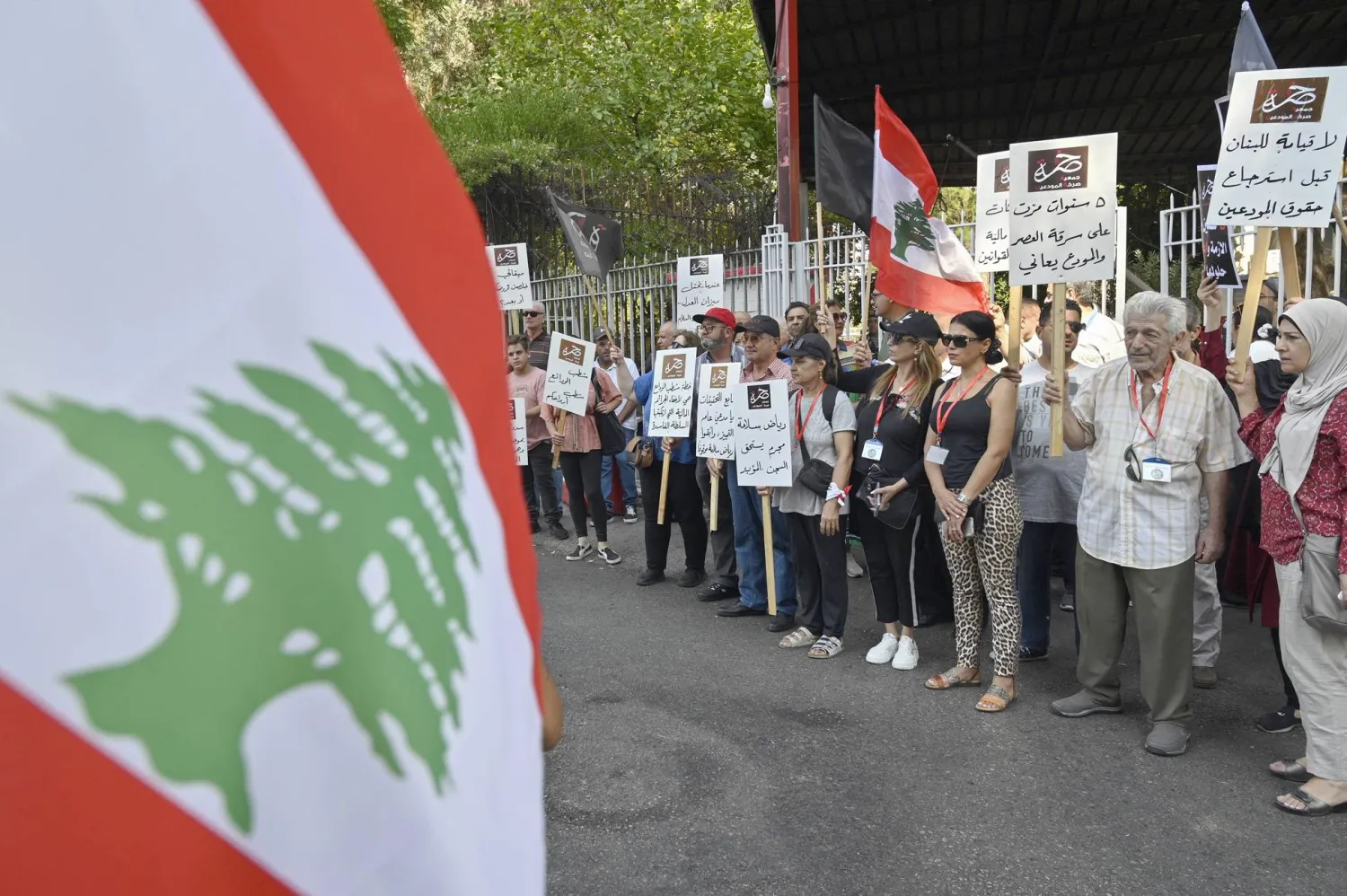 محتجون قرب قصر العدل في بيروت يحملون لافتات تطالب بمحاكمة حاكم مصرف لبنان السابق رياض سلامة (أرشيفية - إ.ب.أ)