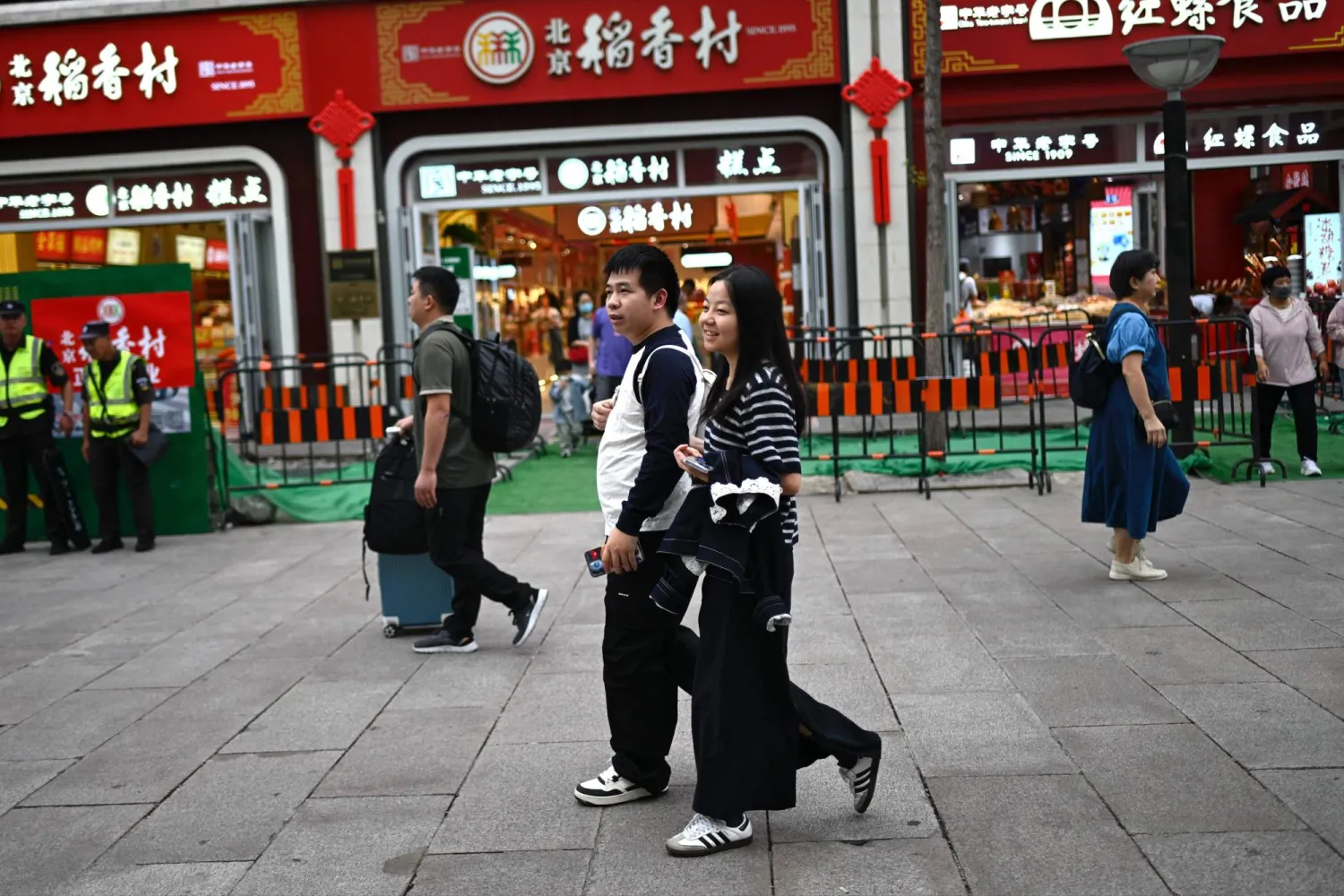 أشخاص يزورون منطقة تسوق في بكين (أ.ف.ب)