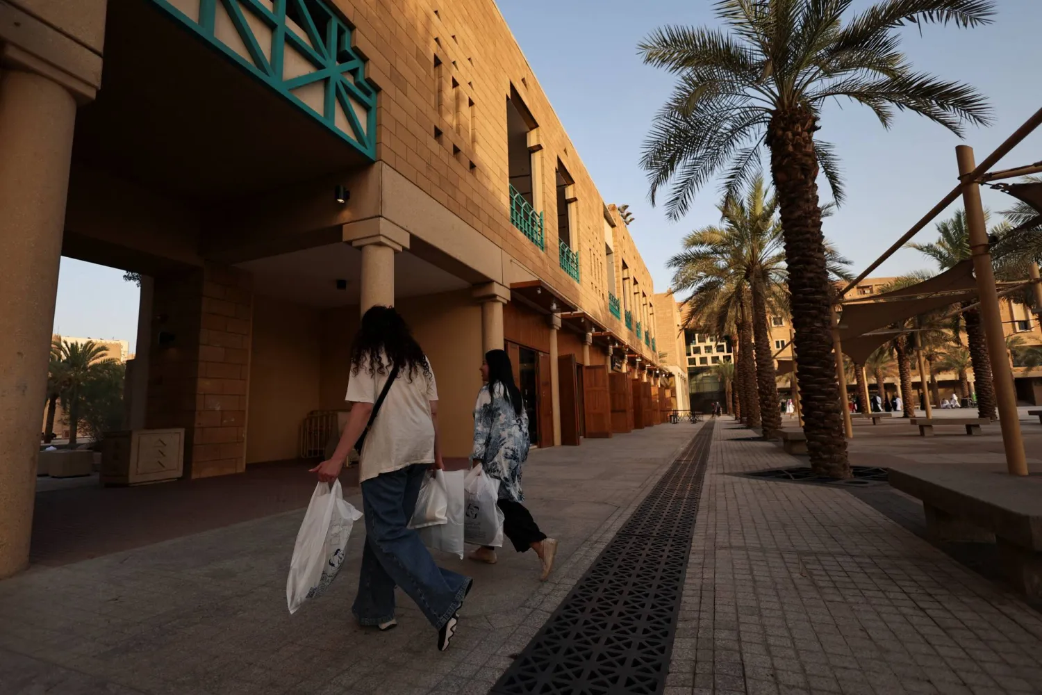 نساء يسرن بأكياس التسوق في إحدى الأسواق المحلية وسط مدينة الرياض (رويترز)