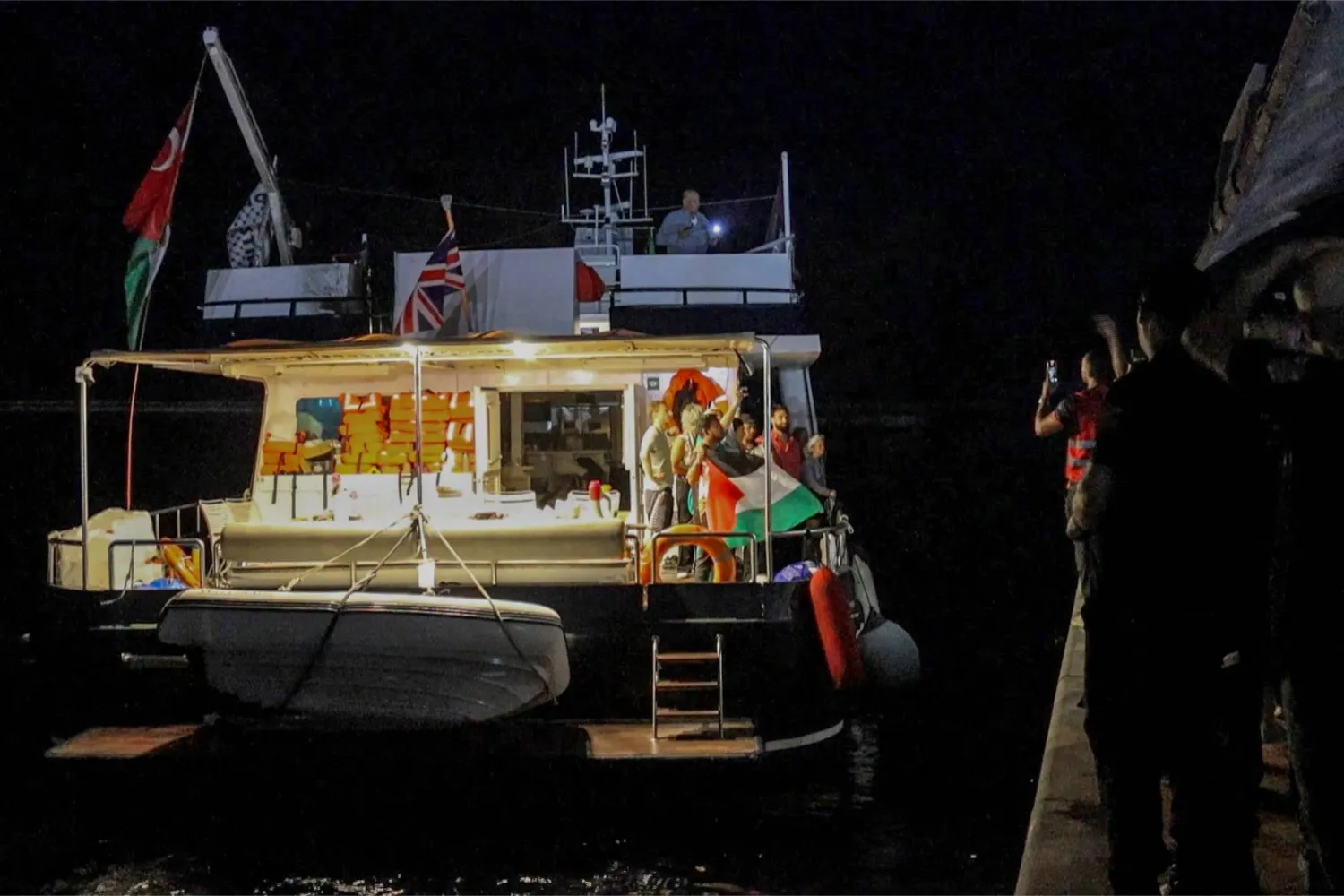 ناشطون على متن اليخت «ألما» الذي يرفع العَلم البريطاني وهو جزء من الأسطول الدولي المتجه إلى غزة مغادراً ميناء بنزرت شمال تونس فجر الاثنين (أ.ف.ب)