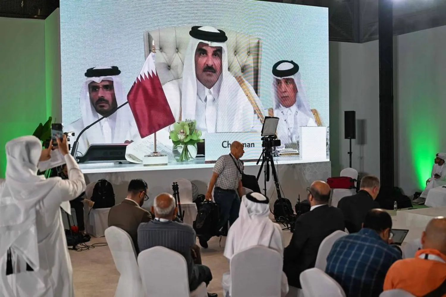 Reporters follow Qatar's Emir Sheikh Tamim bin Hamad Al-Thani's address at the media center, during the opening of the 2025 Arab-slamic emergency summit in Doha on September 15, 2025. (AFP)