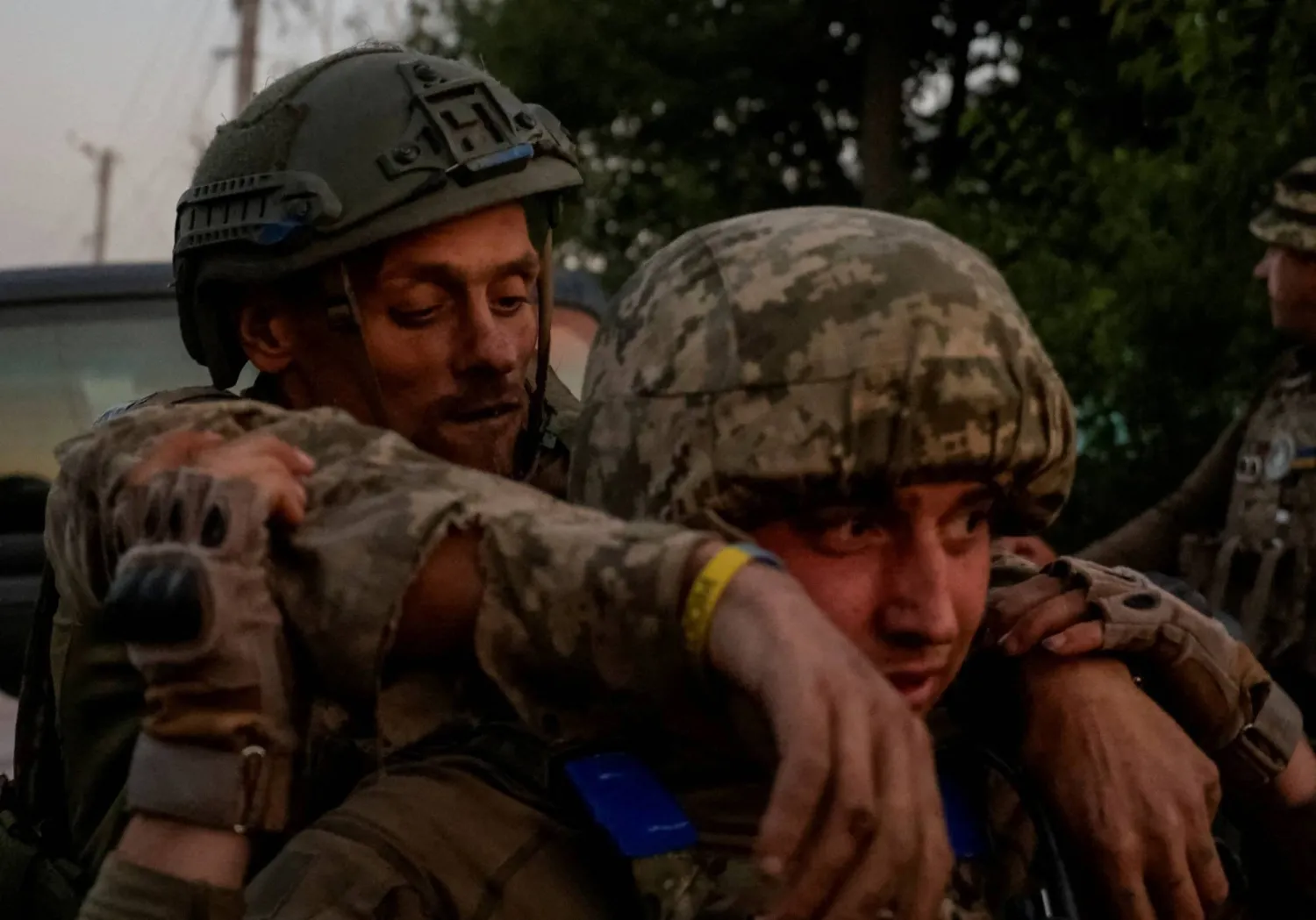 جندي أوكراني يحمل زميلاً له أصيب في منطقة دونيتسك (رويترز) 