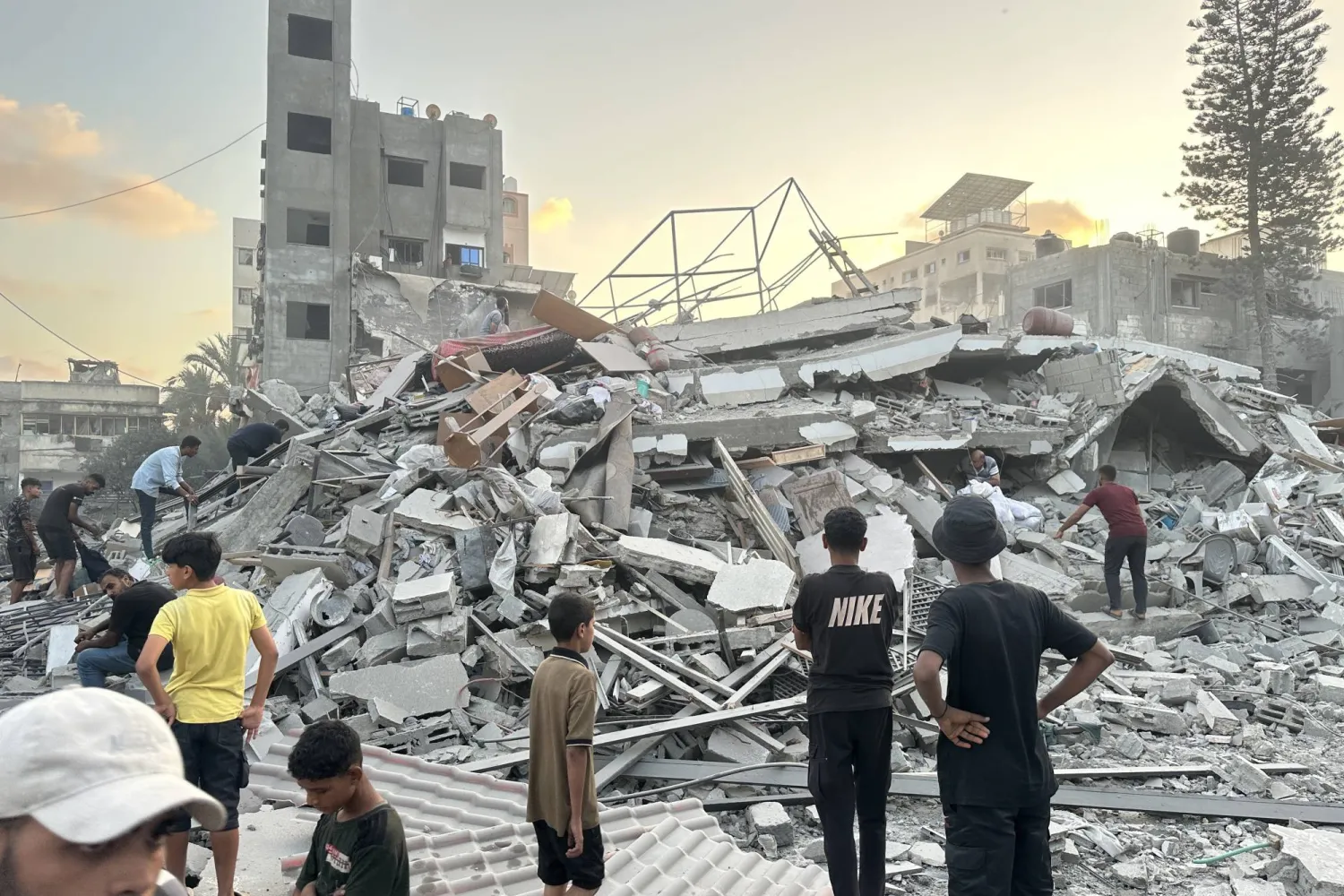 15 September 2025, Palestinian Territories, Gaza: People gather outside a building damaged in an Israeli airstrike west of Gaza City. (dpa)