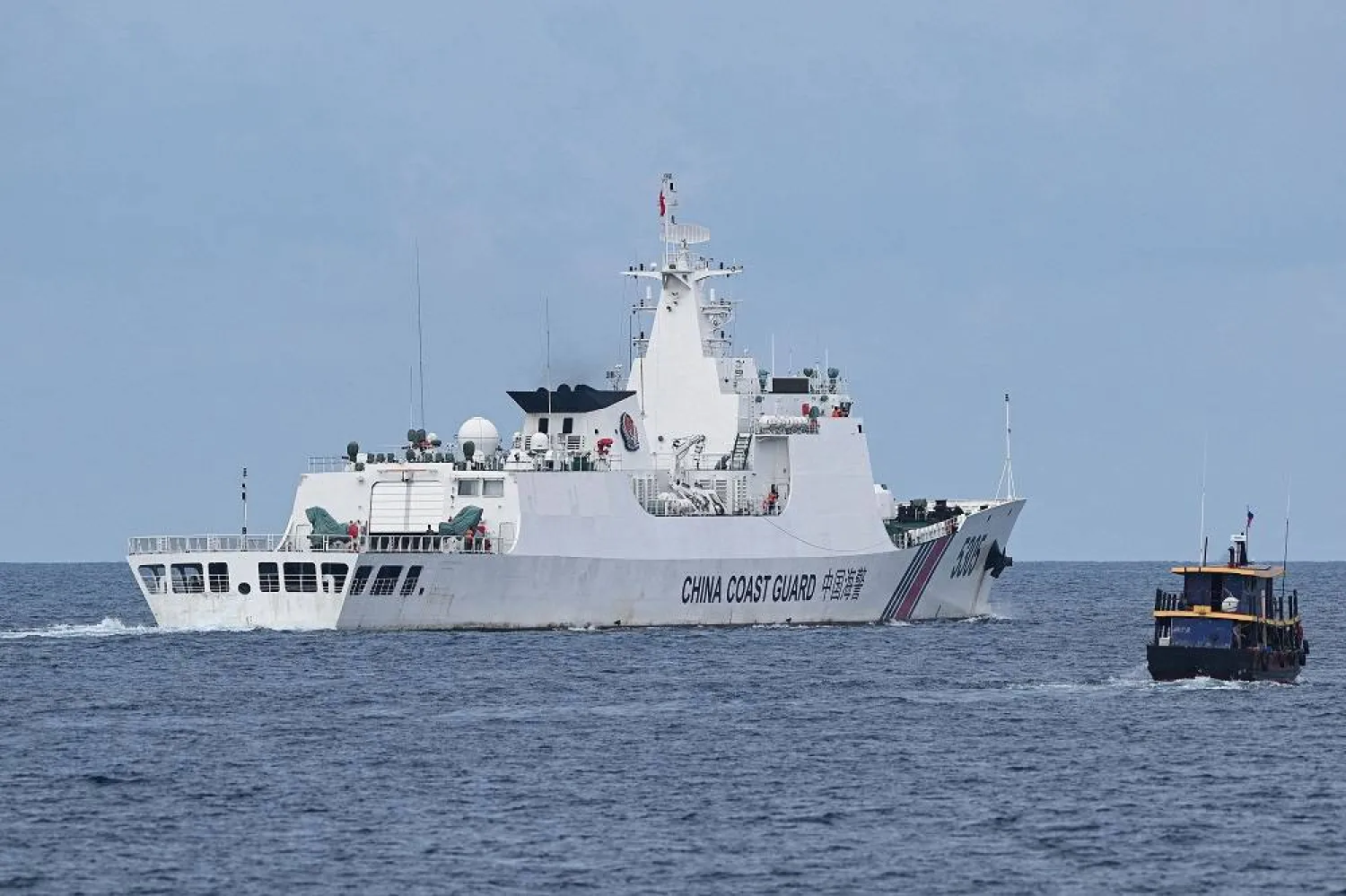 This photo taken on August 22, 2023 shows a Chinese coast guard ship (L) shadowing a Philippine civilian boat chartered by the Philippine navy to deliver supplies to Philippine navy ship BRP Sierra Madre in the disputed South China Sea. (AFP/Getty Images) 