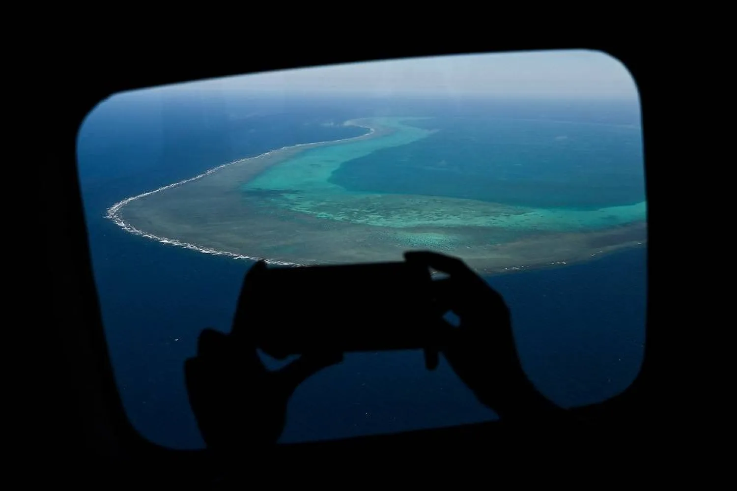A reporter takes a video over the Scarborough Shoal in the disputed South China Sea on February 16, 2024. (AFP)