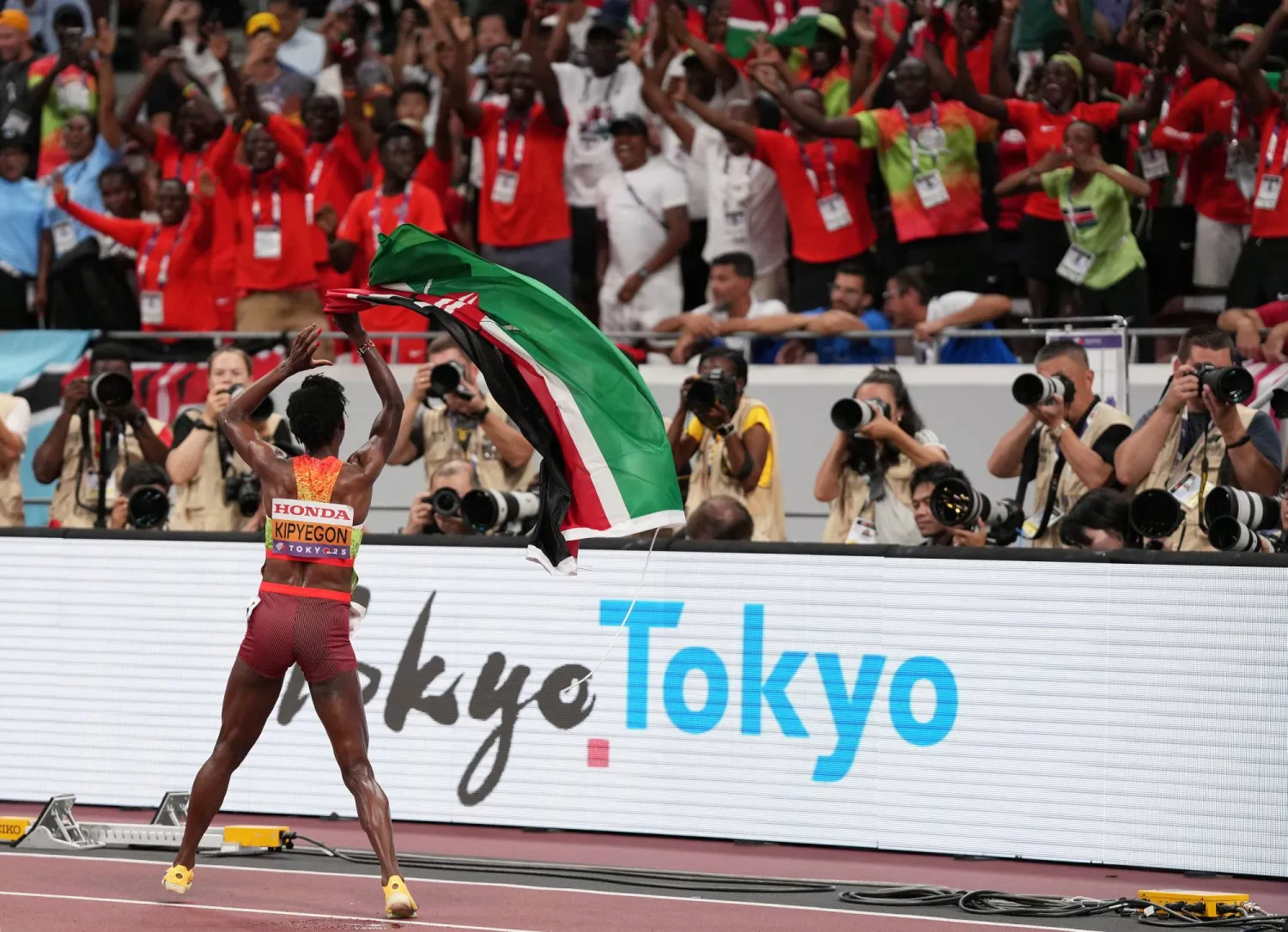 العدّاءة الكينية تحتفل مع الجماهير بالميدالية الذهبية (رويترز)