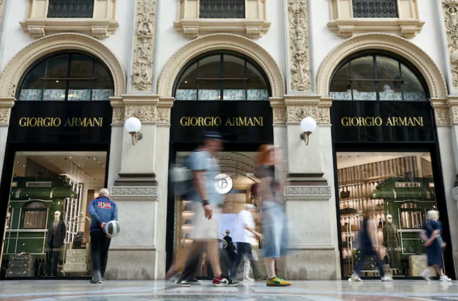 People walk past a Giorgio Armani store in Galleria Vittorio Emanuele II, following Giorgio Armani's death at the age of 91, in Milan, Italy, September 5, 2025. REUTERS/Gonzalo Fuentes/File Photo 