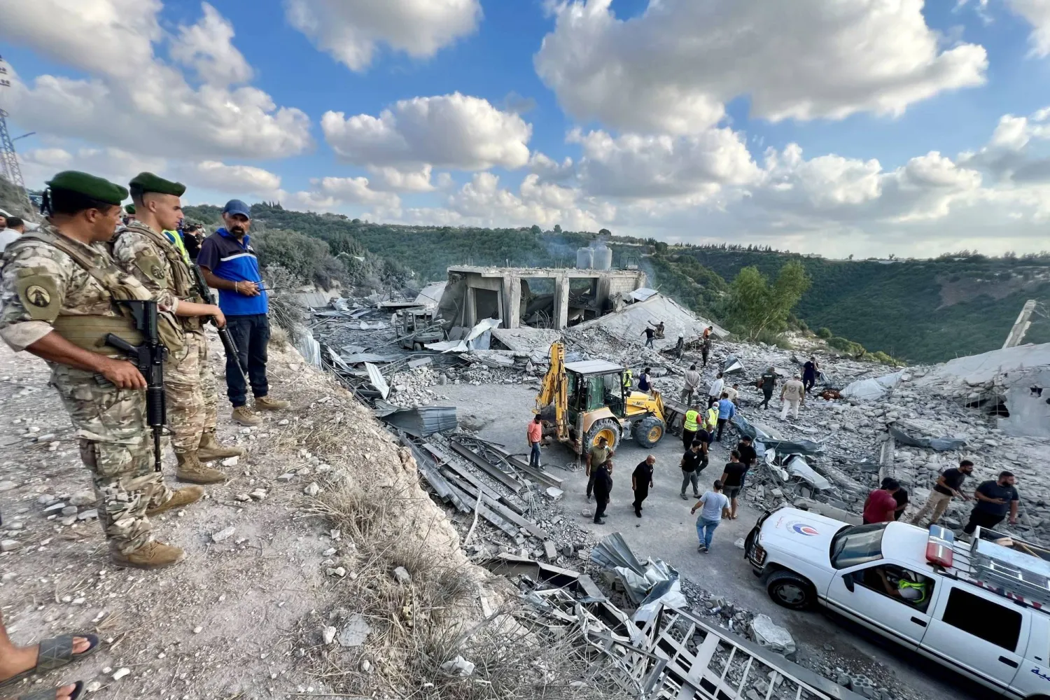 عناصر من الجيش اللبناني يواكبون عمال الإغاثة العاملين في موقع استهداف إسرائيلي في الجنوب الأسبوع الماضي (إ.ب.أ)