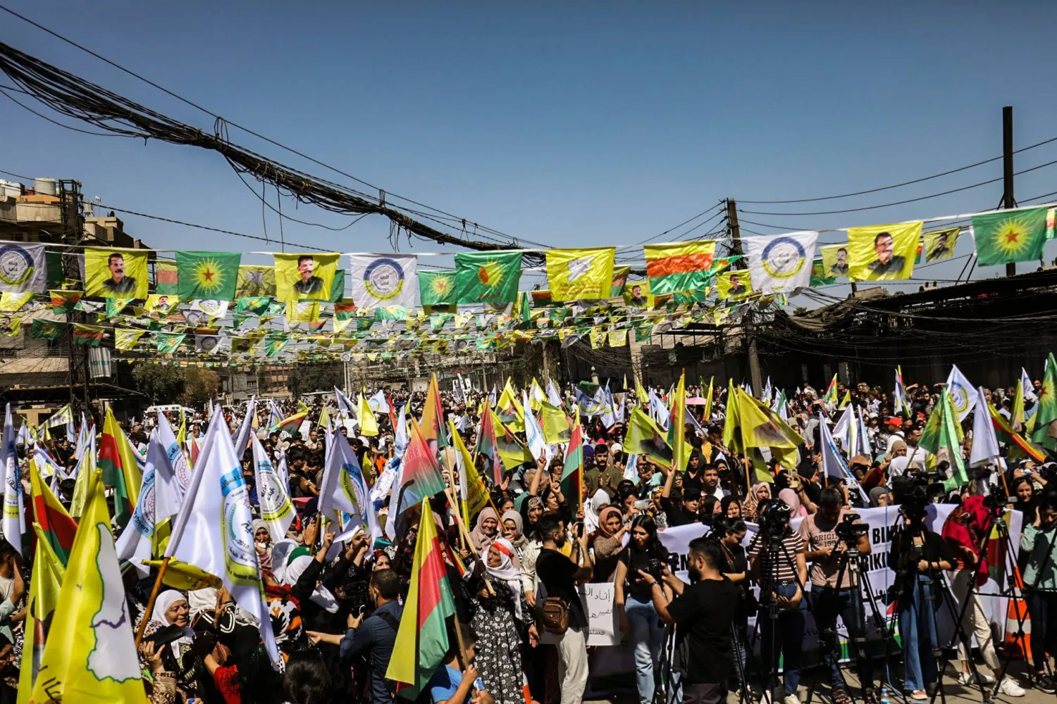 أكراد يرفعون لافتات وأعلاماً خلال مظاهرة في مدينة القامشلي تطالب بإدارة ذاتية في شمال شرق سوريا الأربعاء (أ.ف.ب)