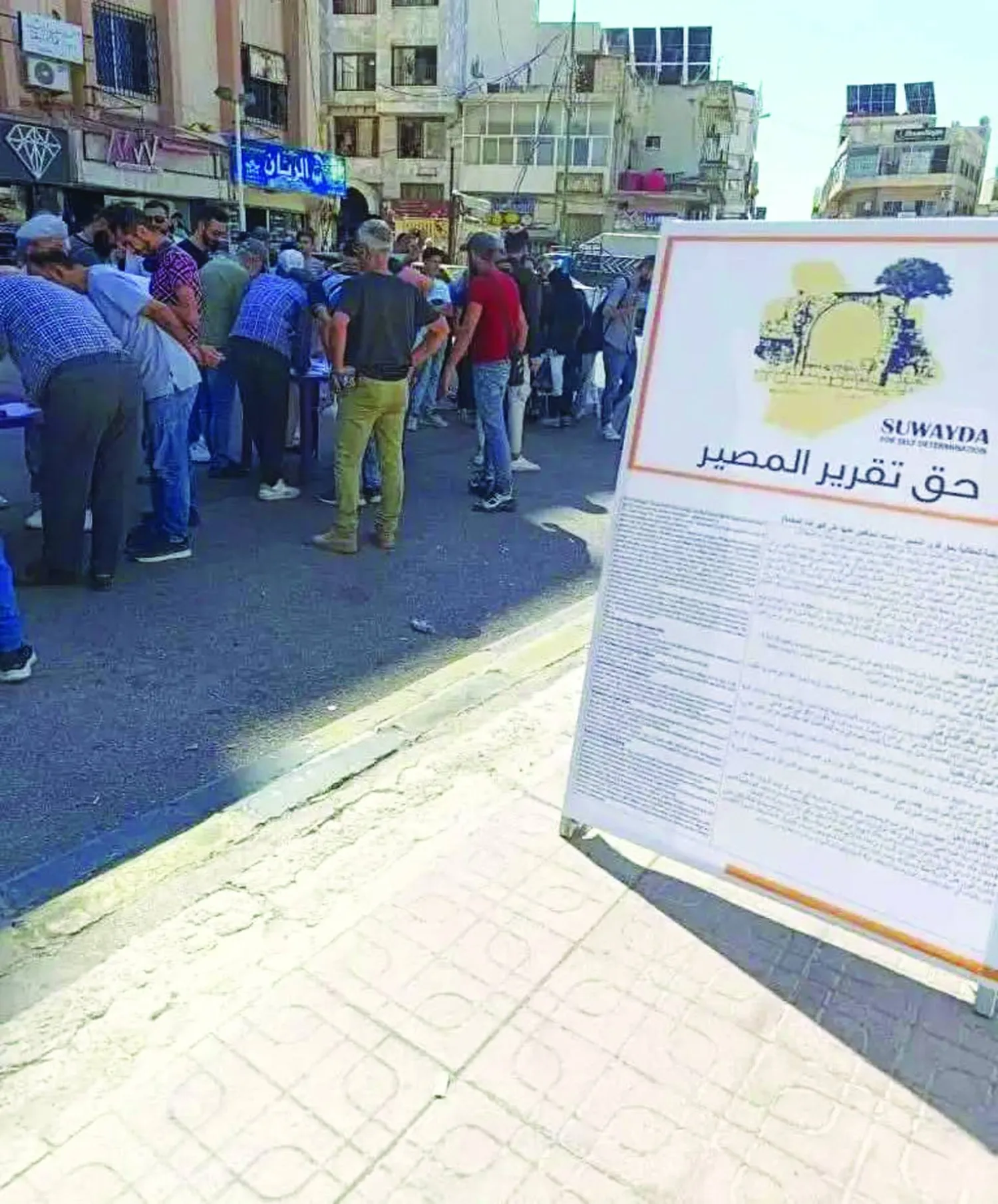 لافتة كبيرة في مدينة السويداء جنوب سوريا تدعو للتوقيع على حملة حق تقرير المصير (أخبار السويداء)