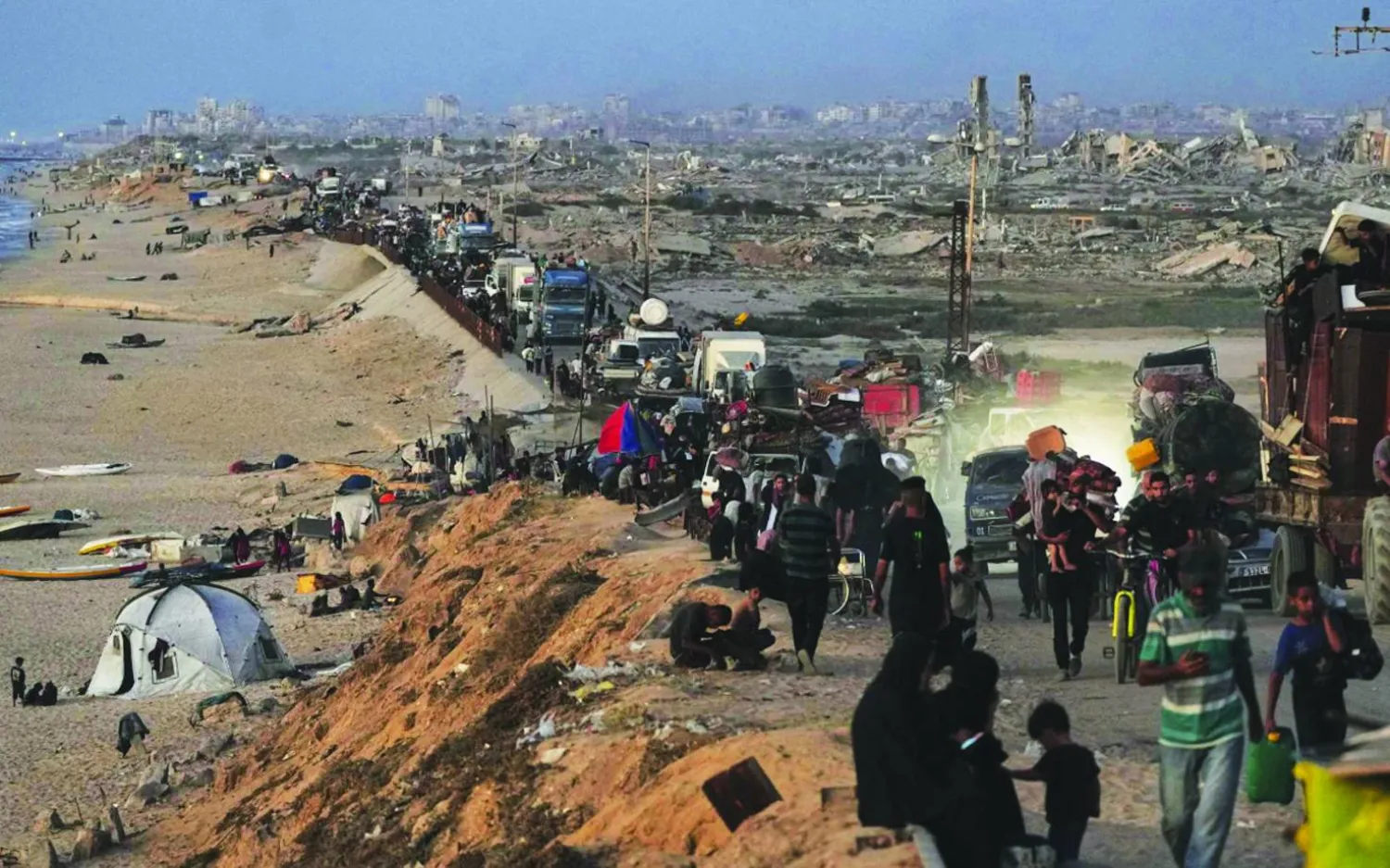 نازحون فلسطينيون يفرون من شمال قطاع غزة عبر الطريق الساحلي باتجاه الجنوب (أ.ب)