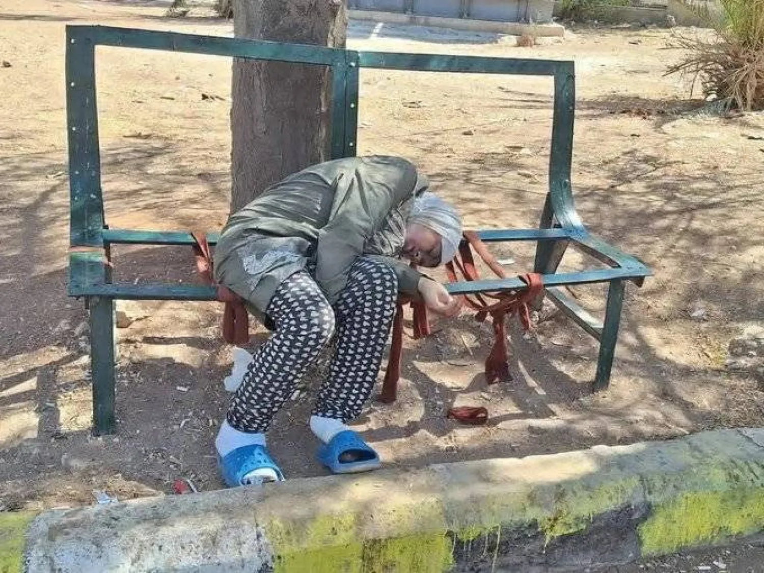 صورة انتشرت على مواقع التواصل لامرأة متوفاة على مقعد في حديقة القباقيب (إكس)