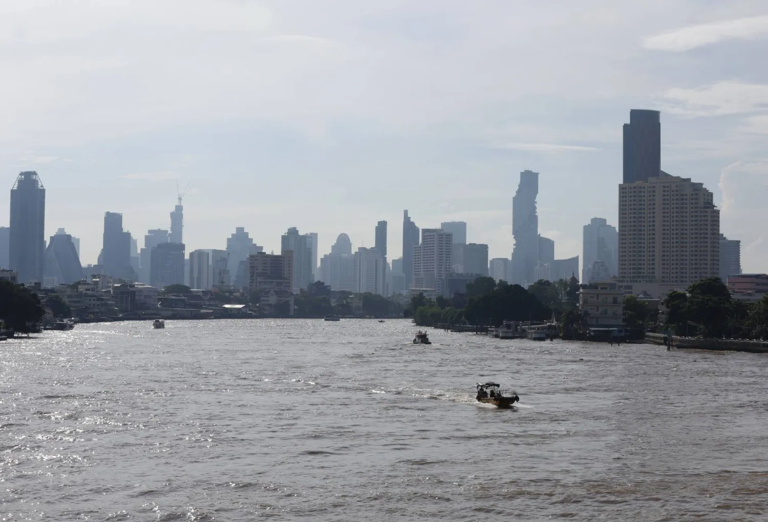 عمال أثناء جمع النفايات والأعشاب الضارة والقمامة من نهر تشاو فرايا في بانكوك (إ.ب.أ)