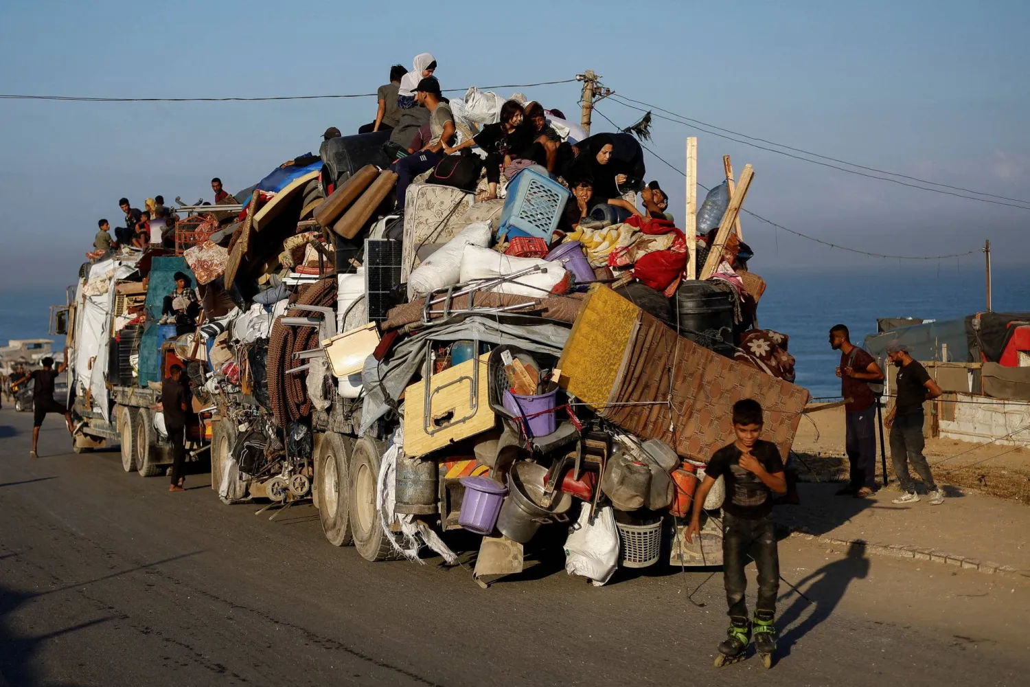 نازحون فلسطينيون يفرون من القصف الإسرائيلي على مدينة غزة باتجاه جنوب القطاع مع أمتعتهم يوم الخميس (رويترز)