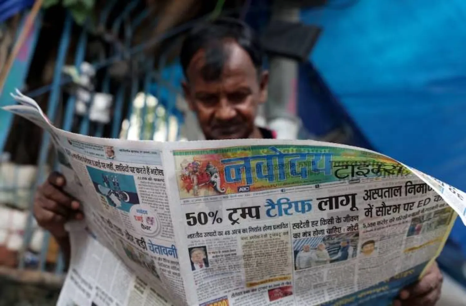 رجل يقرأ صحيفة تتصدرها قصة عن الرسوم الأميركية على معظم السلع الهندية في نيودلهي أغسطس 2025 (رويترز)