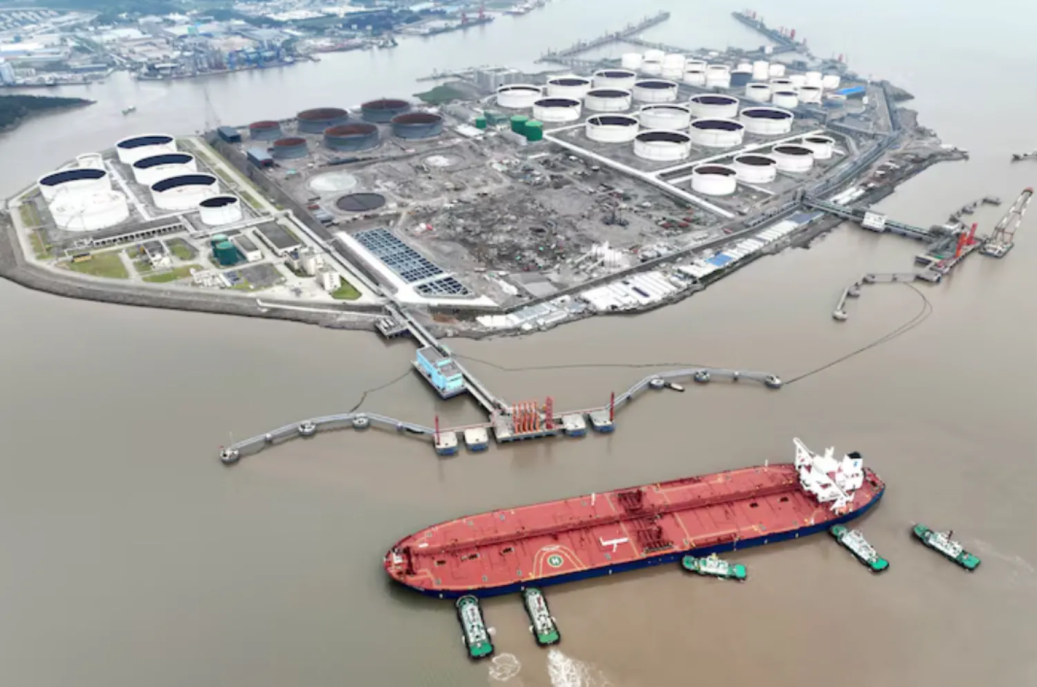 An aerial view shows tugboats helping a crude oil tanker to berth at an oil terminal, off Waidiao Island in Zhoushan, Zhejiang province, China July 18, 2022. cnsphoto via REUTERS/File Photo 