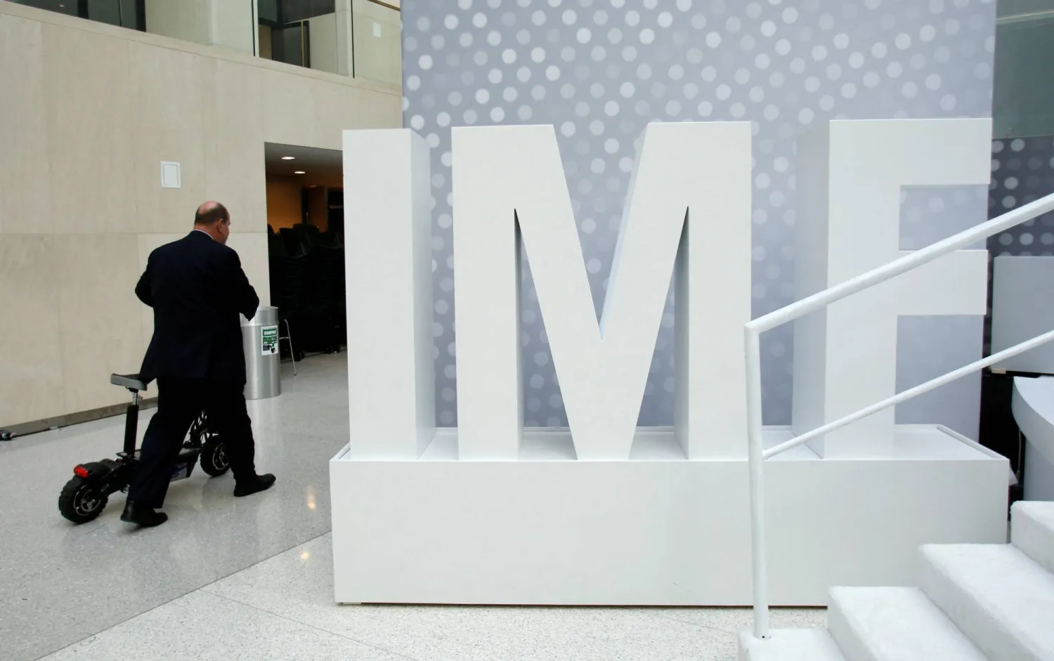 رجل يستقل دراجة «سكوتر» في مقر صندوق النقد الدولي (أرشيفية - رويترز)