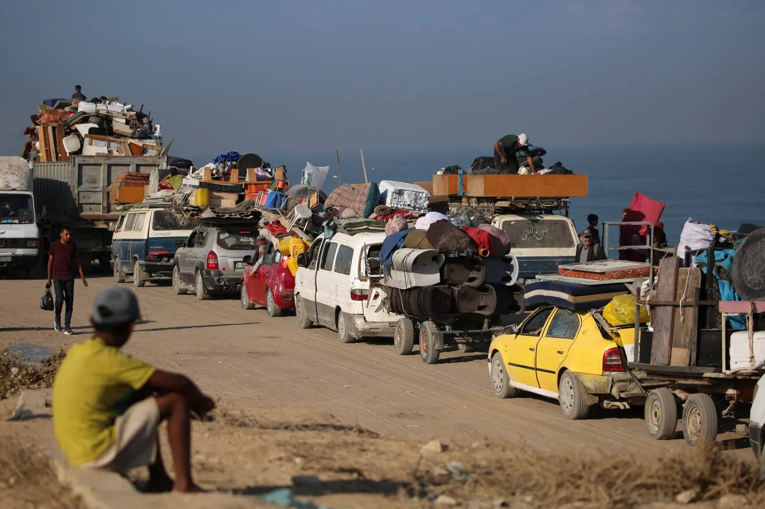 نازحون فلسطينيون مع أمتعتهم يتجهون جنوباً على طريق في منطقة مخيم النصيرات للاجئين وسط قطاع غزة (أ.ف.ب)