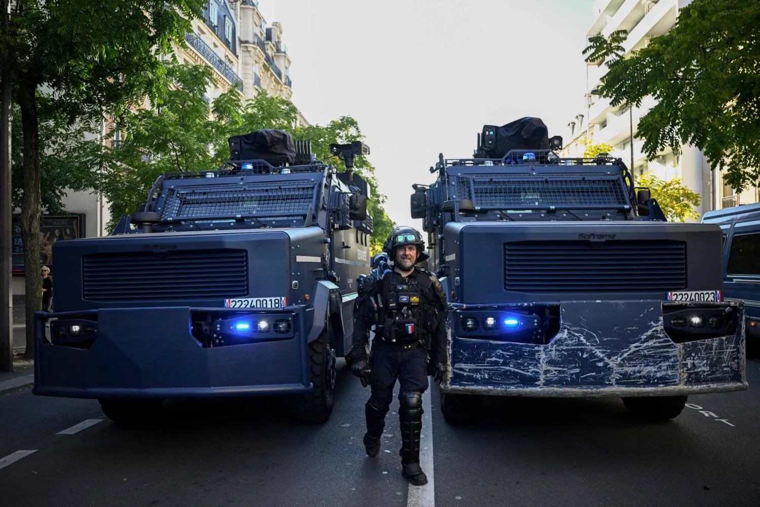 A French police officer stands next to Centaure multipurpose intervention vehicles (VIPG) in the Place de la Nation in Paris, on September 18, 2025. (Photo by JULIEN DE ROSA / AFP)
