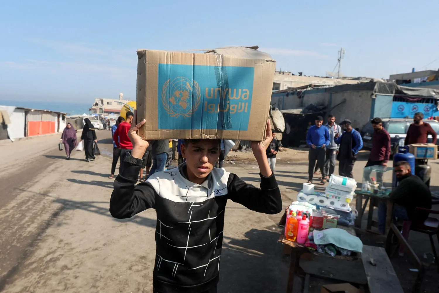 A Palestinian carries an aid box distributed by the United Nations Relief and Works Agency (UNRWA), amid the Israel-Hamas conflict, in Deir Al-Balah, central Gaza Strip, November 4, 2024. (Reuters) 